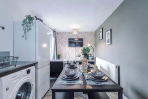 Cozy living space with a kitchenette, dining area, and flat-screen TV.