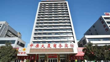 A multi-story building with a prominent entrance and signage indicating it is a hotel.