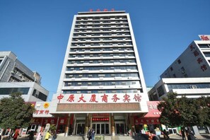 A multi-story building with a prominent entrance and signage indicating it is a hotel. - Zhongyuan Dasha Business Hotel (Zhengzhou)