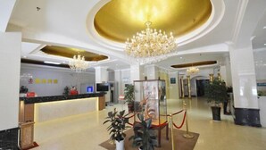 A hotel lobby with a reception desk, a chandelier, and potted plants. - Zhongyuan Dasha Business Hotel (Zhengzhou)