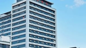 A high-rise building with multiple floors, featuring a modern architectural design with a grid-like facade and numerous windows. - Zhongyuan Dasha Business Hotel (Zhengzhou)