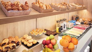 Un bufé con diversos alimentos, incluyendo pasteles, frutas y postres.