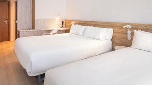 Una habitación de hotel con dos camas, un escritorio y una silla.