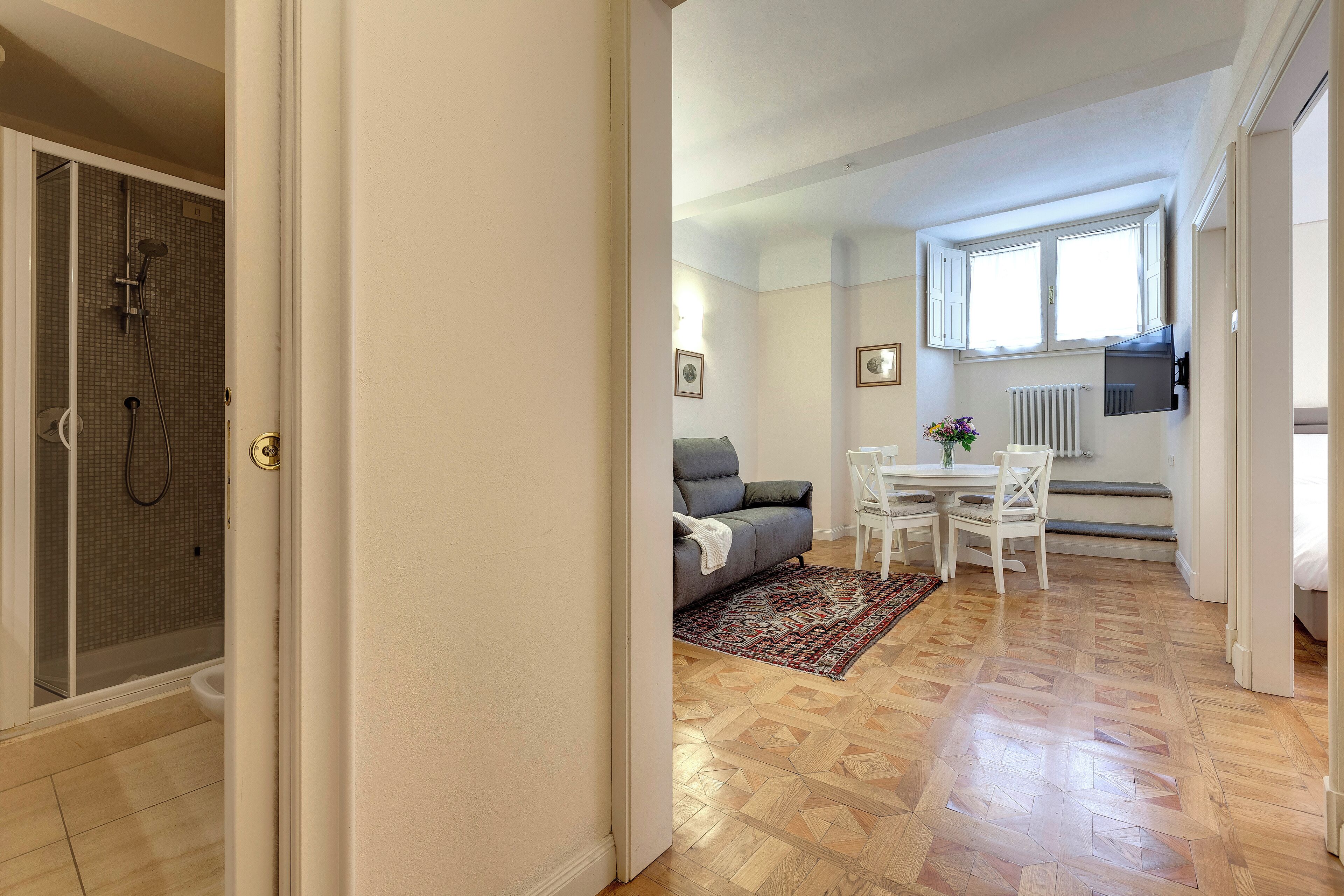 Un appartement moderne doté d’une douche, d’un coin repas et d’un espace de vie.