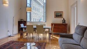 Una sala de estar moderna con comedor, ventanas amplias y vistas a un edificio histórico.