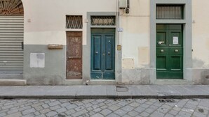 A building with three doors, each with a number above it. - Mamo Florence - Maddalena Apartment (Florence)