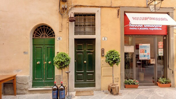 A building with green doors and a sign for a restaurant. - Mamo Florence - Magazzini Apartment (Florence)