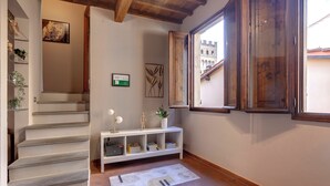 A staircase leading to a landing with a white console table, a framed certificate, and a painting. - Mamo Florence - Magazzini Apartment (Florence)