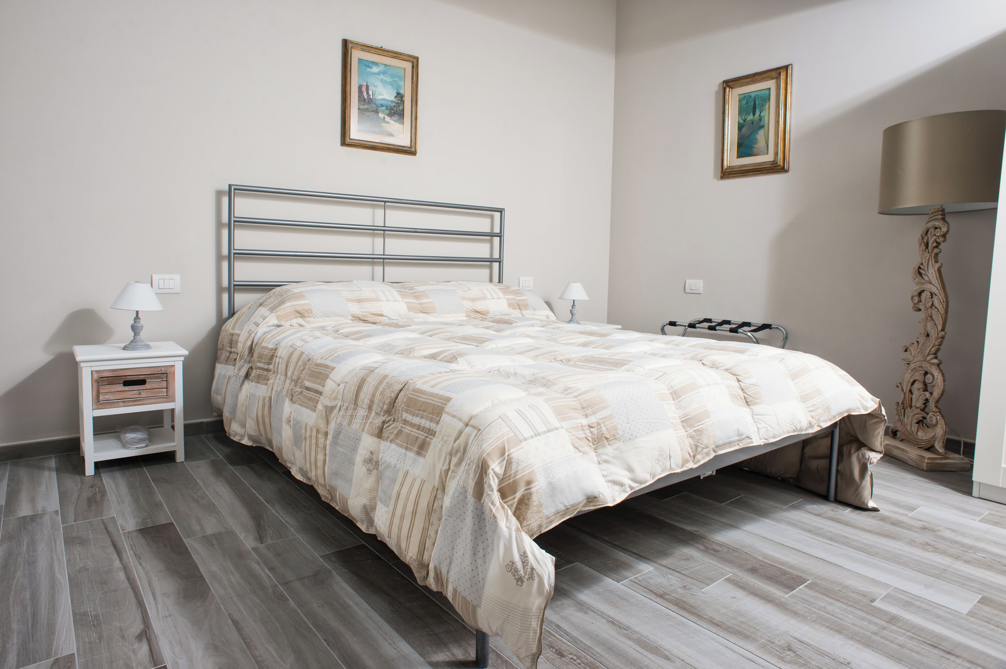 A bedroom with a bed, nightstands, and a lamp.