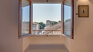 A room with a large window offering a view of a cityscape. - Mamo Florence - Pinti Apartment (Florence)