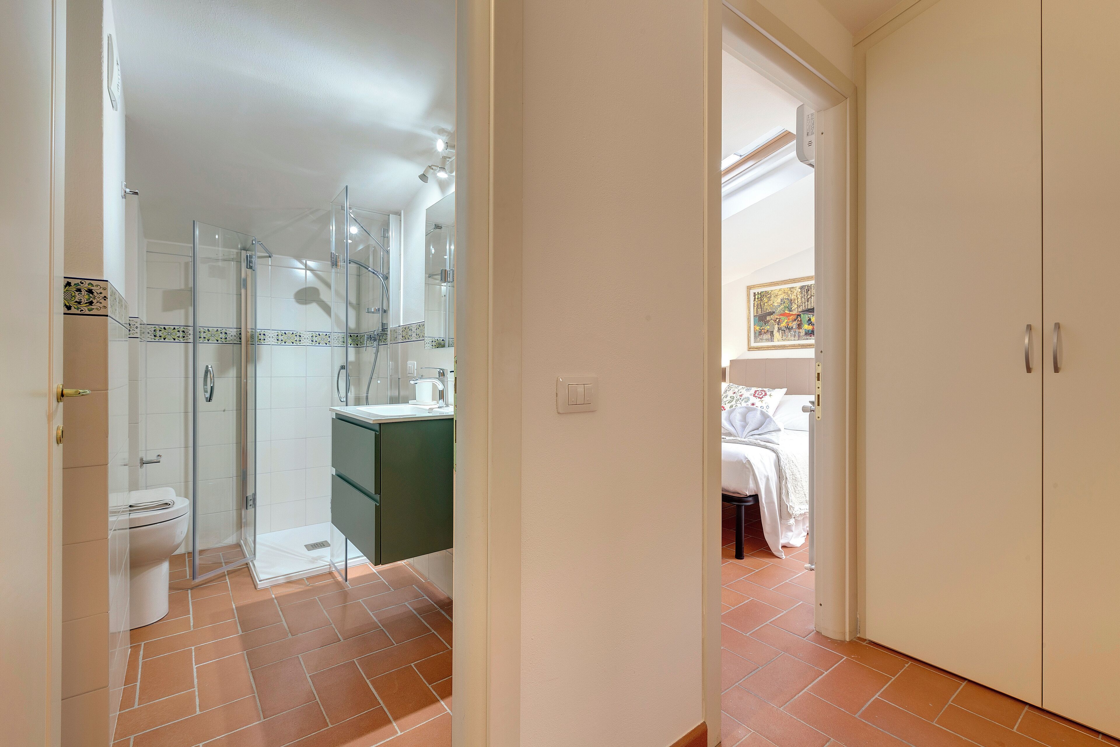 A bathroom with a toilet, shower, and sink.