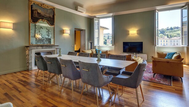 A spacious living area with a dining table, chairs, a fireplace, a large mirror, and a sofa. - Mamo Florence - Tintori Luxury Palace (Florence)
