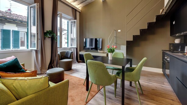 Una sala moderna con comedor, una escalera y una cocina.