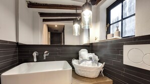 A modern bathroom with a freestanding bathtub, a wooden vanity, a large mirror, and a window with a view. - Mamo Florence - Vigna Vecchia Studio (Florence)