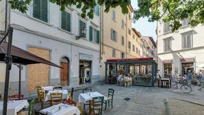 Une rue pavée avec des tables et des chaises installées à l’extérieur d’un restaurant.