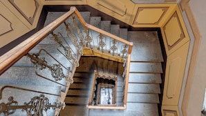 A grand staircase with ornate metal railings and a central open landing. - Mamo Florence - Zante Aparment (Florence)
