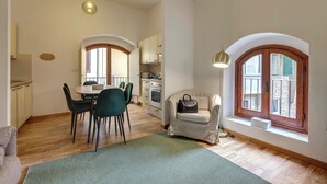 Un amplio espacio de estar con una mesa de comedor, sillas, un sofá y una ventana con vistas.