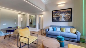 A modern living room with a dining area, a sofa, and a painting on the wall. - Mamo Florence - Sant'Agostino Luxury Apartment (Florence)