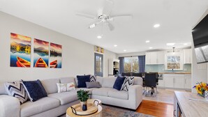 A modern living room with a grey sectional sofa, a round coffee table, and a ceiling fan. - Winchester TN lake house rental, Tims Ford Lake vacation home,private boat ramp (Winchester)