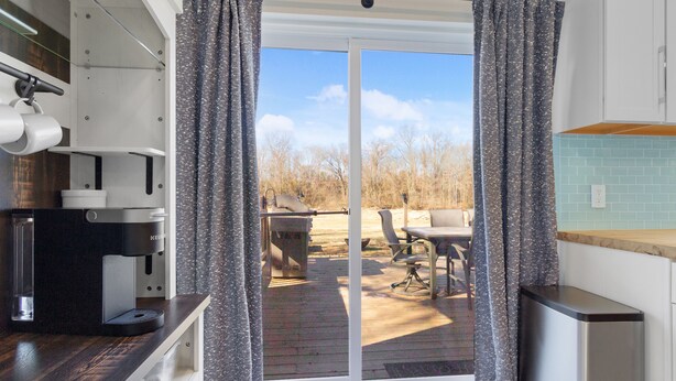 A modern kitchen with a built-in coffee maker, a sliding glass door leading to an outdoor patio with a table and chairs. - Winchester TN lake house rental, Tims Ford Lake vacation home,private boat ramp (Winchester)