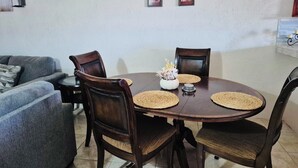A dining area with a round table, four chairs, and a decorative centerpiece. - 3-bedroom house in brilliant Potters Village with AC (Potters Village)