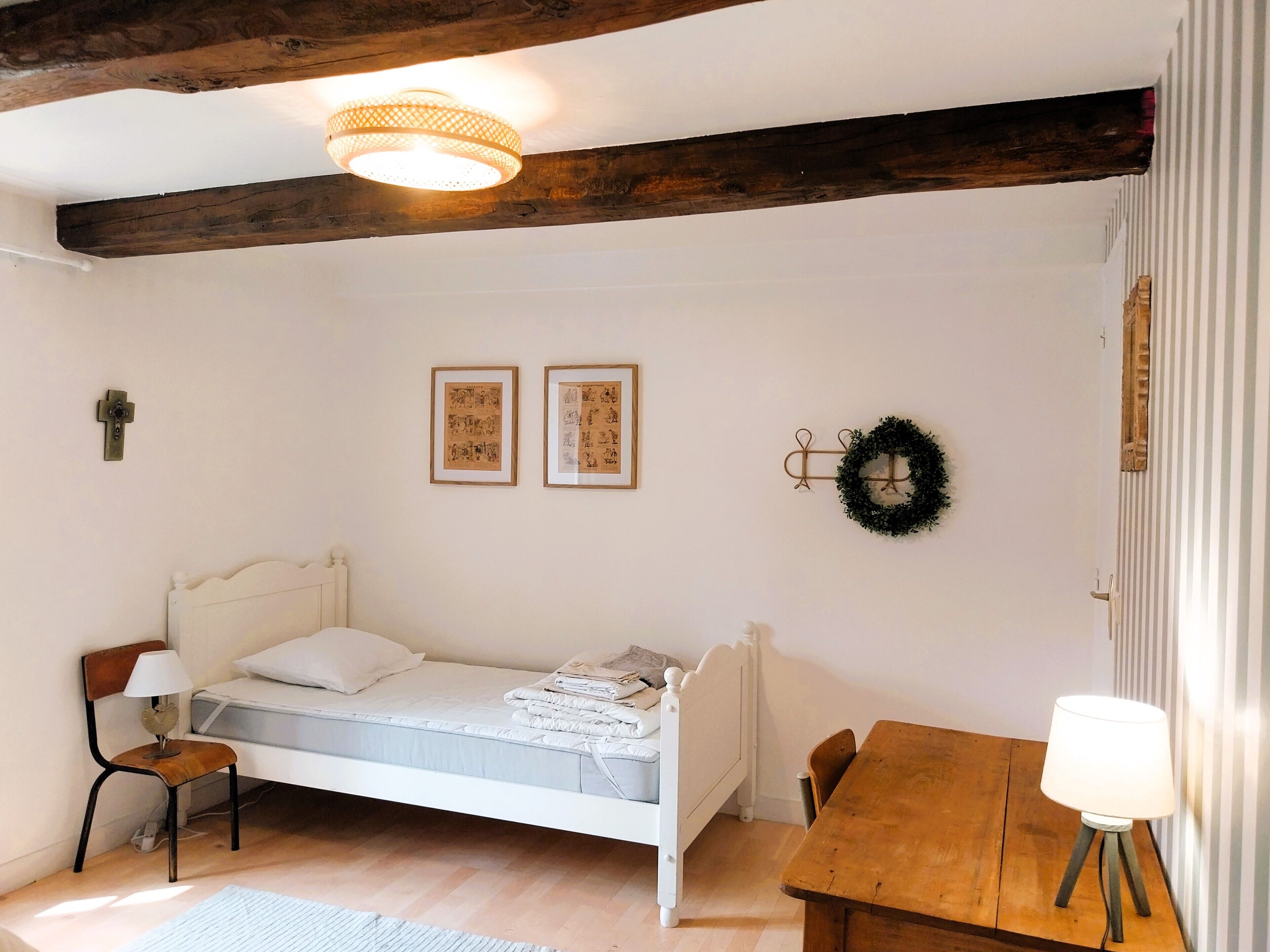 Une chambre confortable avec un lit simple, une table en bois et une petite chaise.