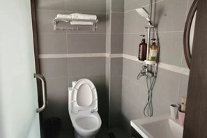 Un baño con inodoro, ducha y lavamanos.