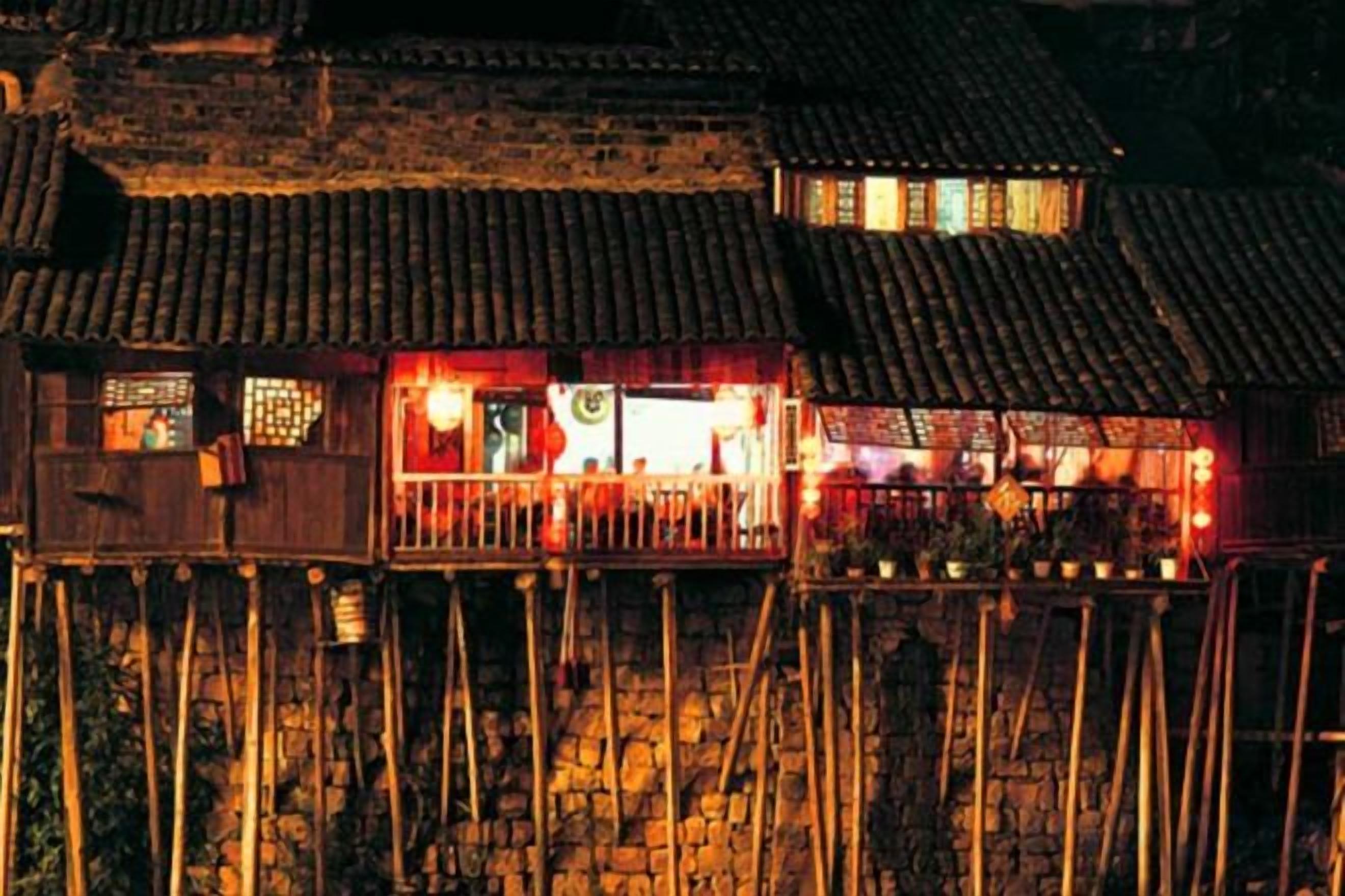 A traditional building with a balcony, stone walls, and a tiled roof.