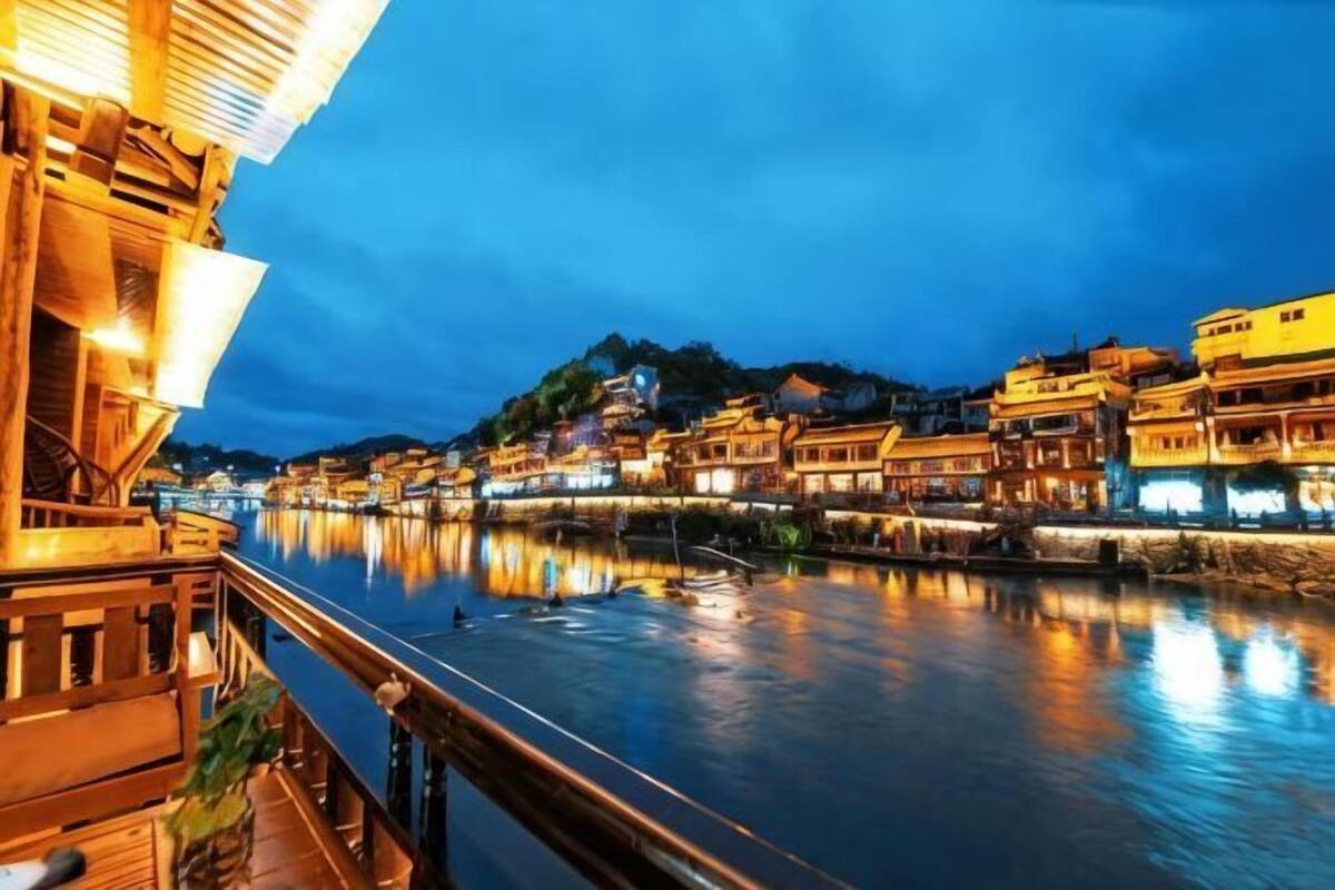 A riverside view of traditional buildings with a wooden structure on the left.