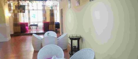 A room with wicker furniture, a round table, and a view of the outside.