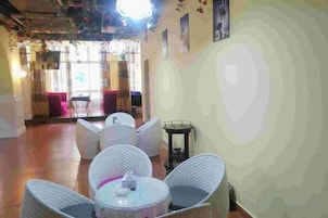 A room with wicker furniture, a round table, and a view of the outside.