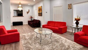 A modern living room with a red sofa, a glass coffee table, and a white shag rug. - Lincoln Ave Home By Naval Base! (North Chicago)