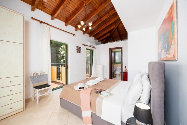 Ein Schlafzimmer mit einem Bett, einem Sessel, einem Kleiderschrank und einem Balkon.
