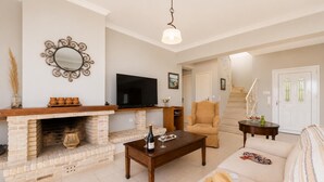 A living room with a fireplace, a television, a sofa, and a coffee table.