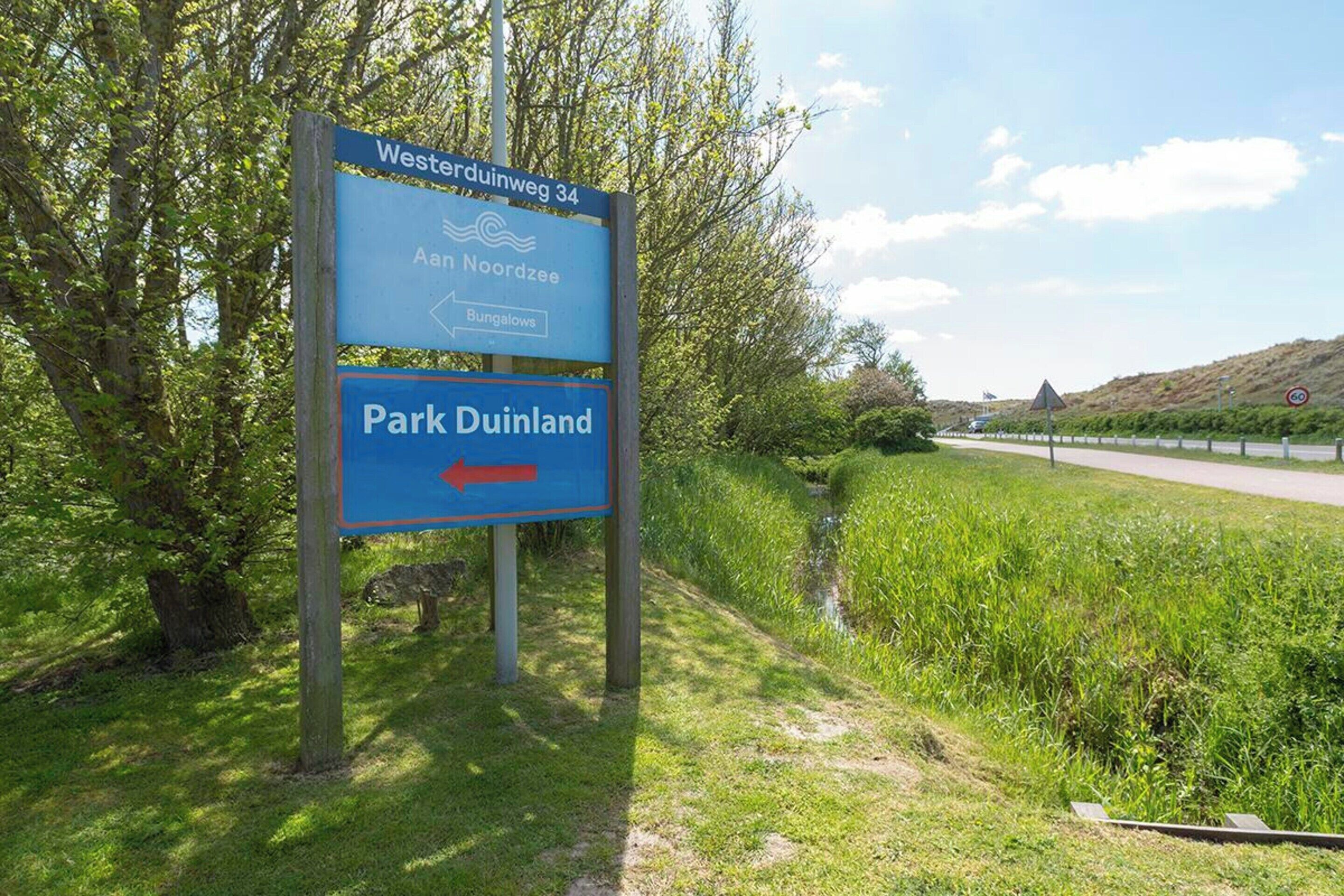 A directional sign for Westerduinweg 34, Aam Noordzee, and Park Duinland with an arrow pointing to the right.