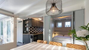 A compact living space with a dining area, kitchenette, and a bedroom. - Duinland 110 Bungalow in Sint Maartenszee (Sint Maartensvlotbrug)