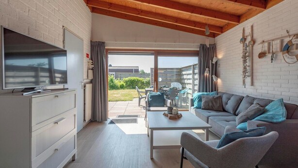 A modern living room with a television, sofa, and coffee table. - De Blenck 67 Family-friendly Bungalow (Callantsoog)