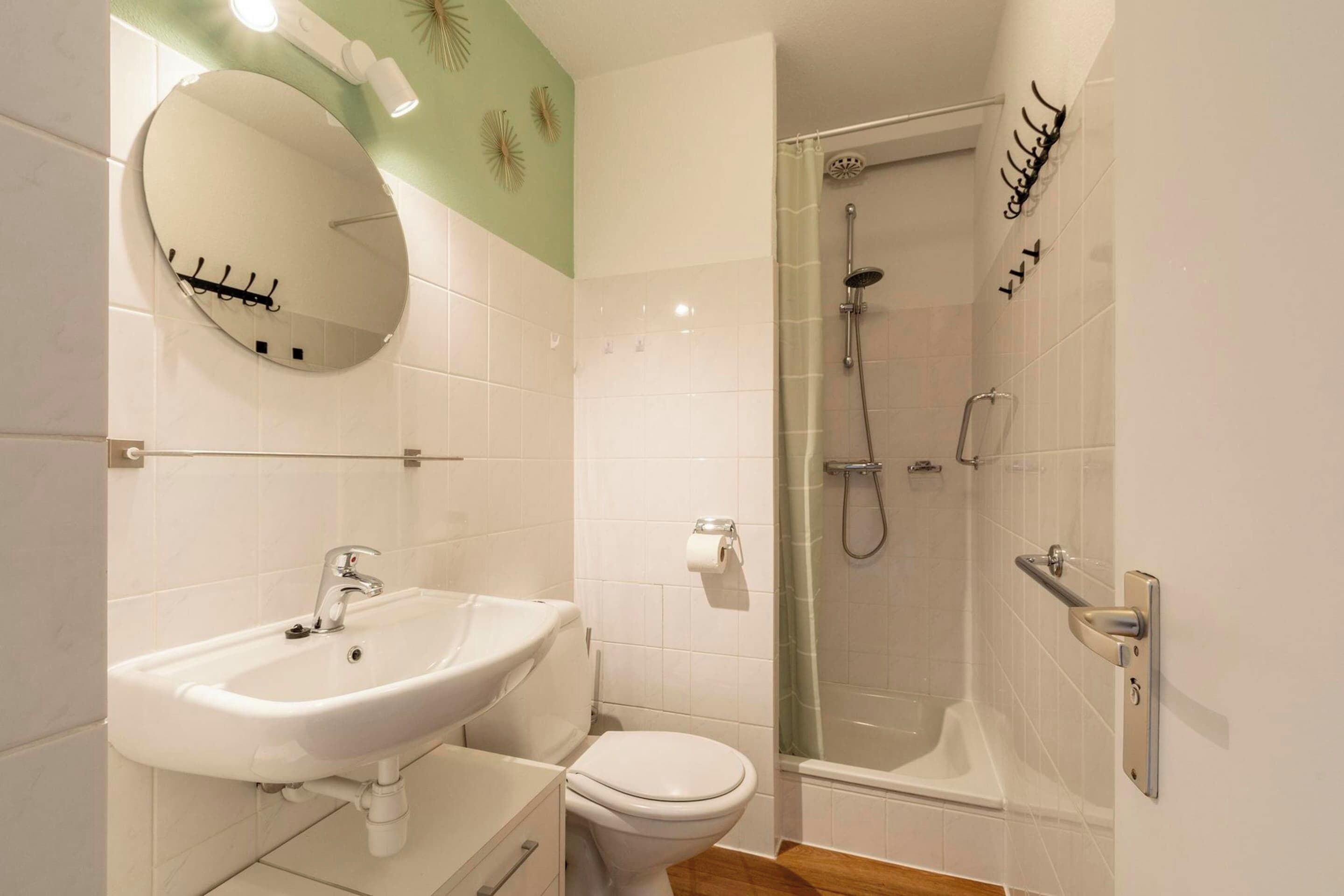 A bathroom with a sink, toilet, and glass-enclosed shower.