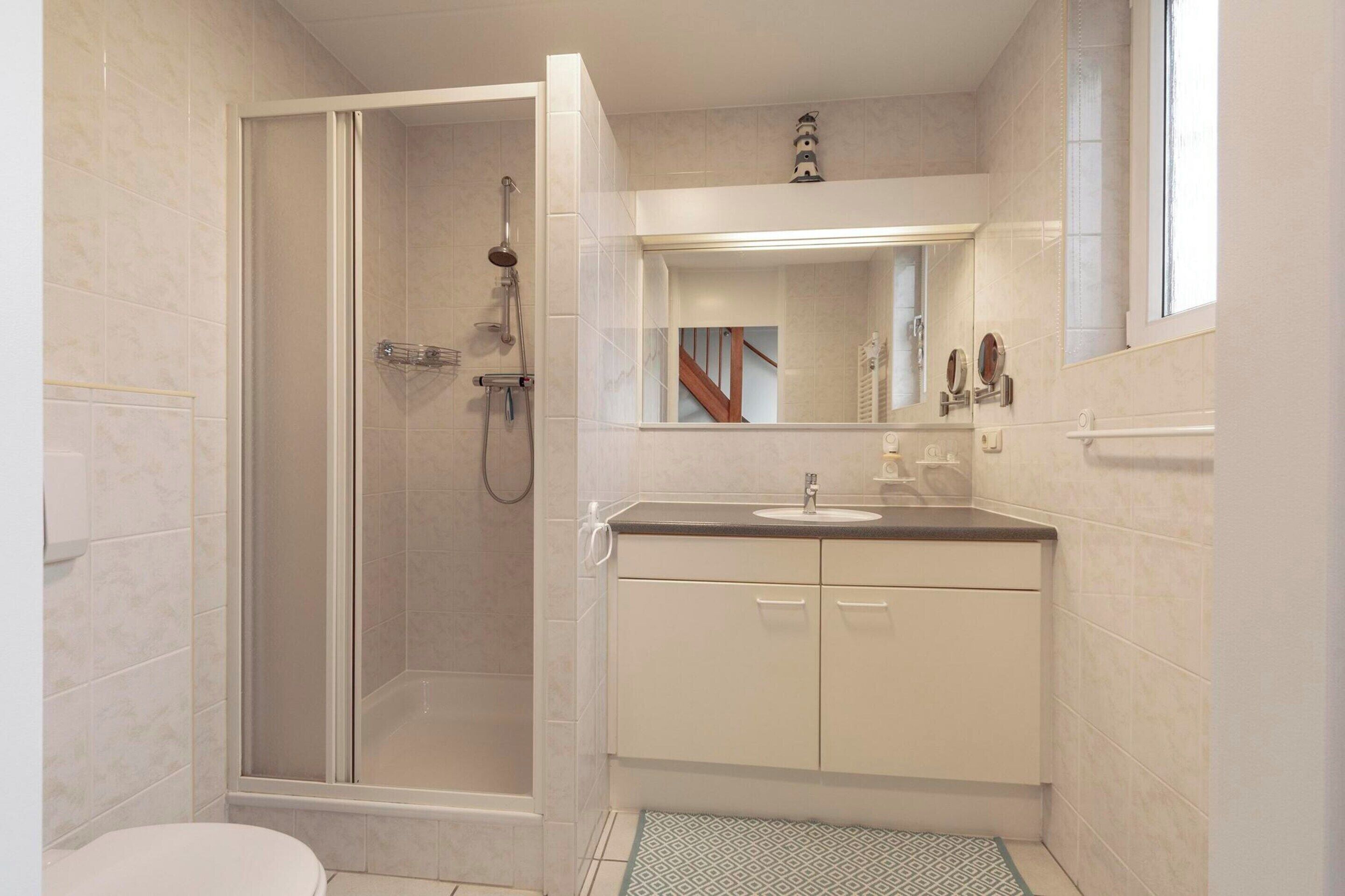 Ein Badezimmer mit Dusche, Toilette und Waschbecken.