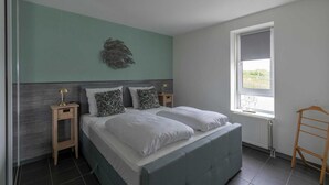 A bedroom with a bed, two bedside tables, a window, and a radiator. - Callantsduyne 21 With Groote Keeten Dune View (Callantsoog)