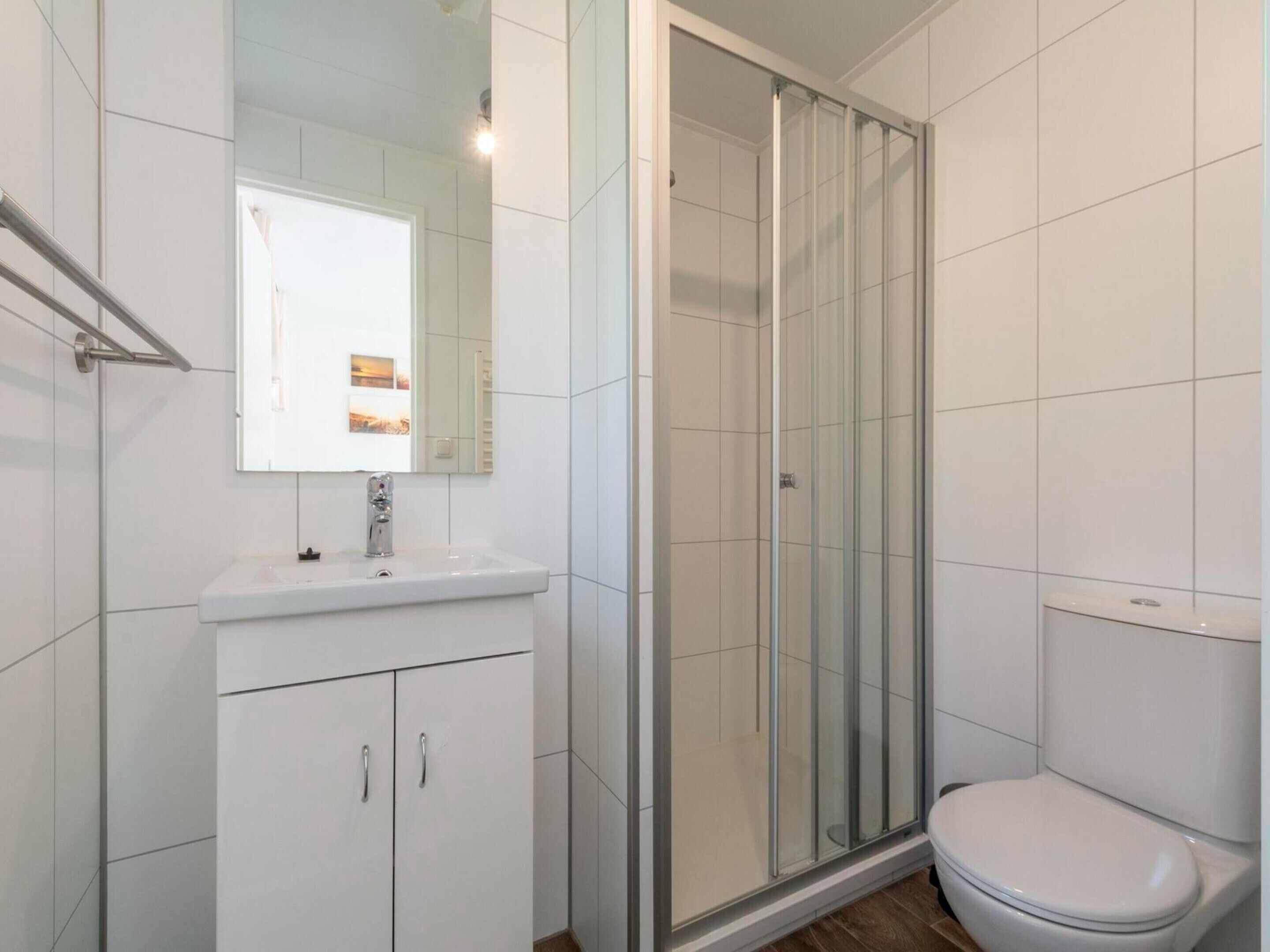 A bathroom with a shower, toilet, and sink.