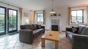 A living room with two grey sofas, a wooden coffee table, and a fireplace.