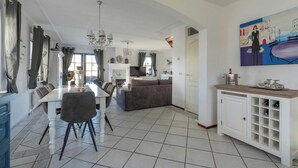 A spacious living area with a dining table, sofas, and a kitchen in the background. - Villa in Callantsoog Near Beach & Sea (Callantsoog)