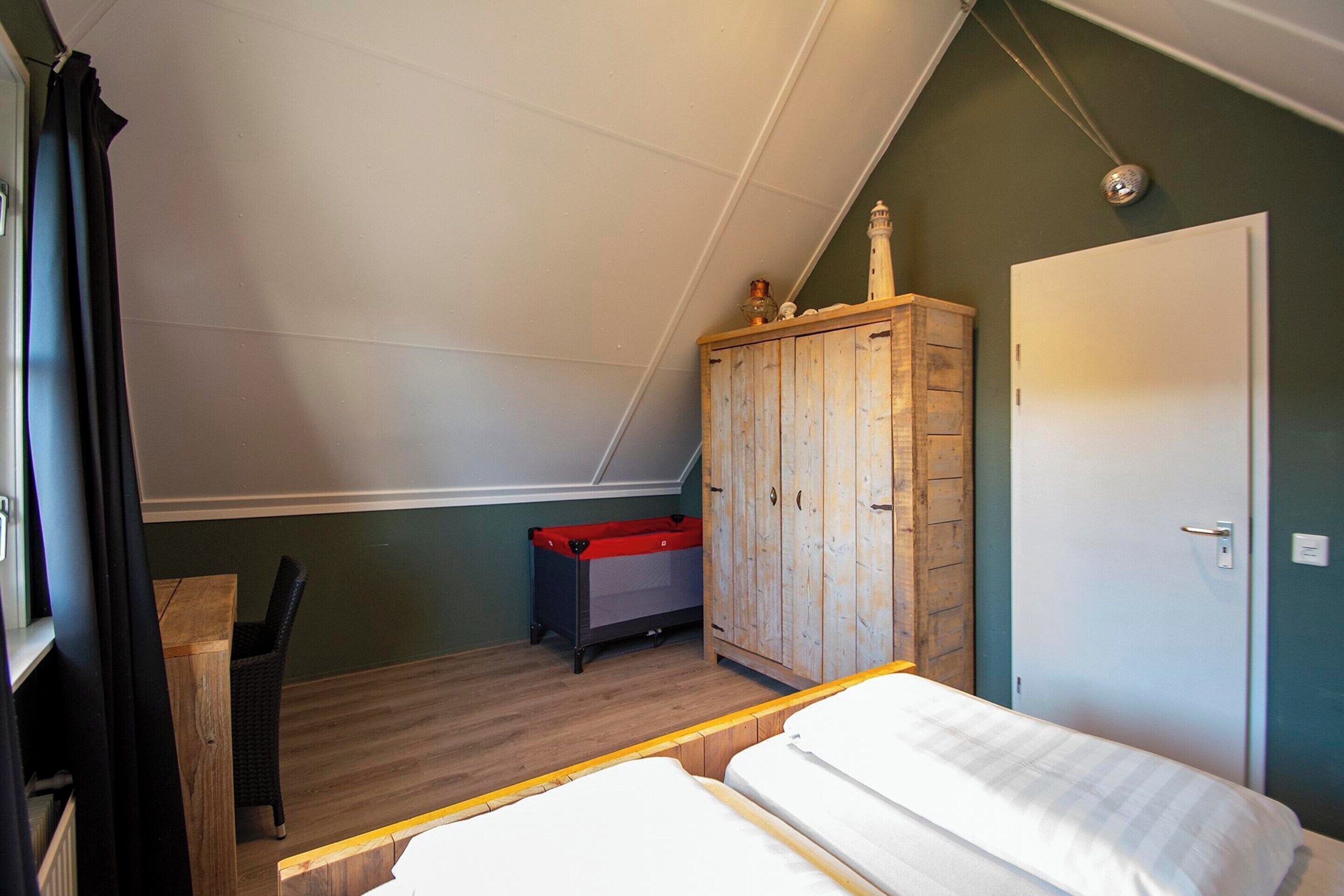 Une chambre à coucher avec un lit, une armoire, un bureau et une chaise.