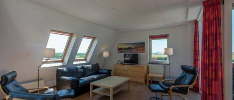 A modern living room with a sofa, two armchairs, a coffee table, and a TV. There are two windows with curtains, a painting on the wall, and a red curtain on the right.