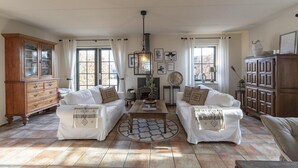 Un salon chaleureux avec deux canapés blancs, une table basse en bois et une cheminée.