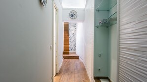 A narrow hallway with wooden flooring, a staircase with floral wallpaper, and a skylight. - La Perla del Duomo With Terrace by Wonderful Italy (Catania)