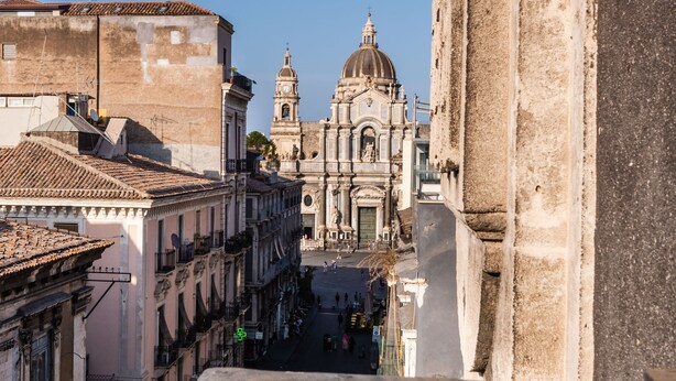 A street view with a prominent church and adjacent buildings. - La Perla del Duomo With Terrace by Wonderful Italy (Catania)