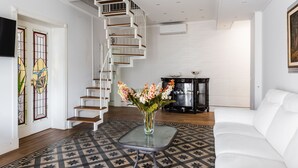 A modern living room with a white staircase, a glass coffee table, and a white sofa. - La Perla del Duomo With Terrace by Wonderful Italy (Catania)