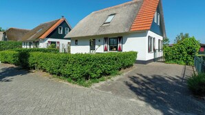 A traditional house with a steeply pitched roof, a small window, and a paved driveway. - Villa in Callantsoog Near Beach and Dunes (Callantsoog)